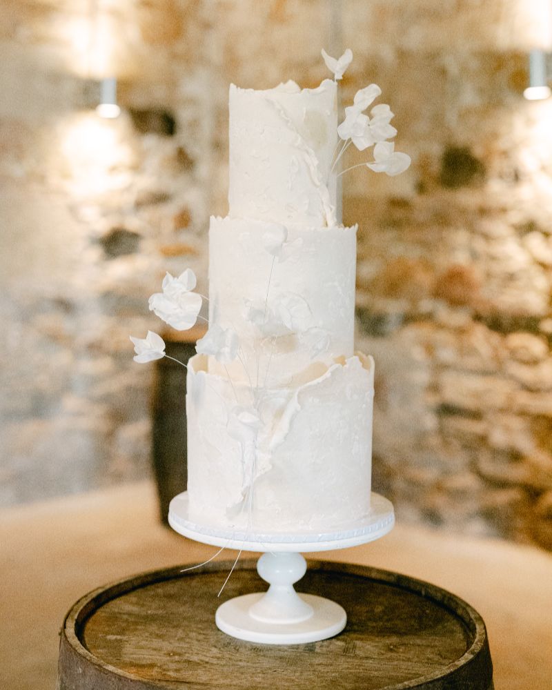 a white wedding cake with flowers in white