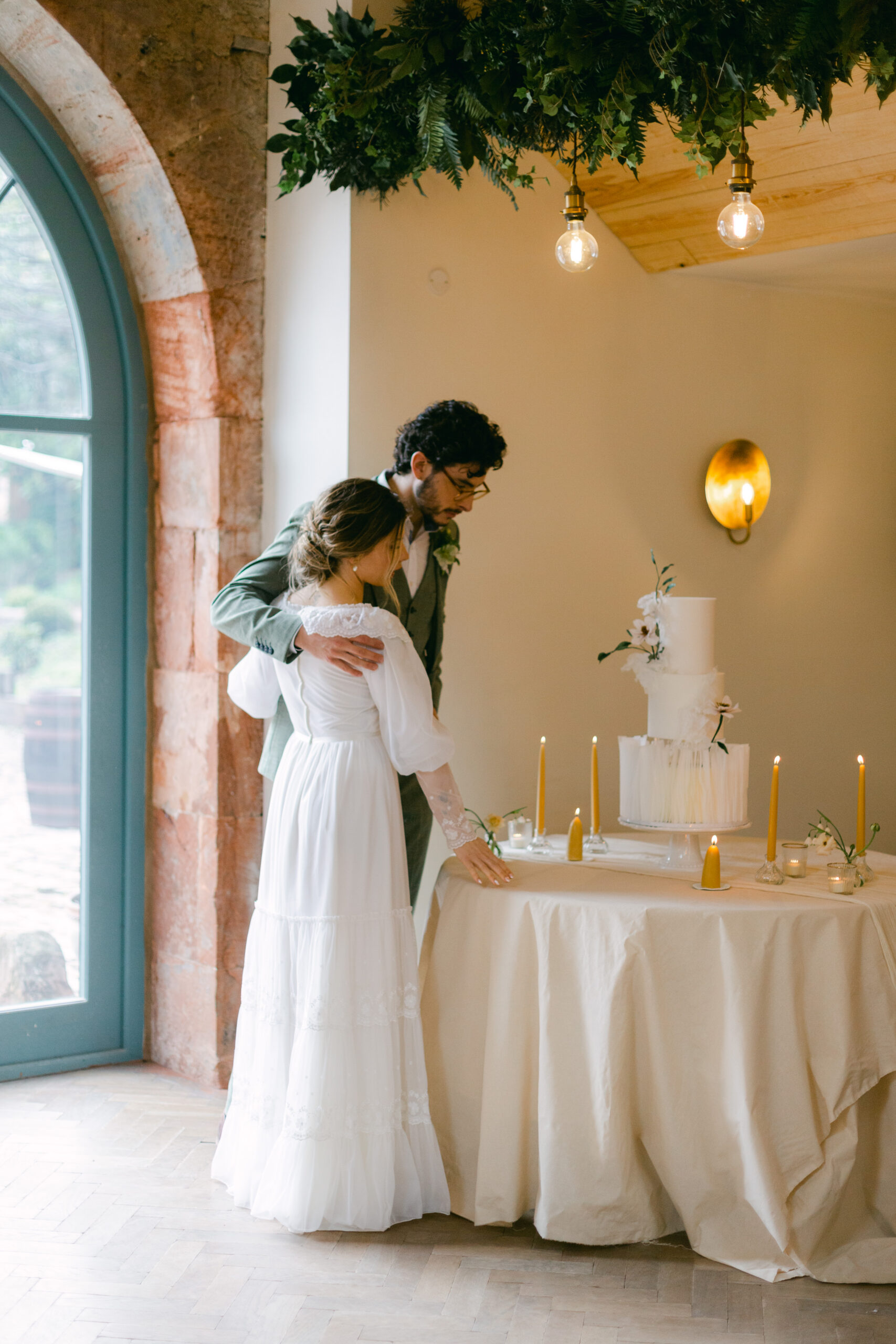 a bride and groom looking at their wedding cake